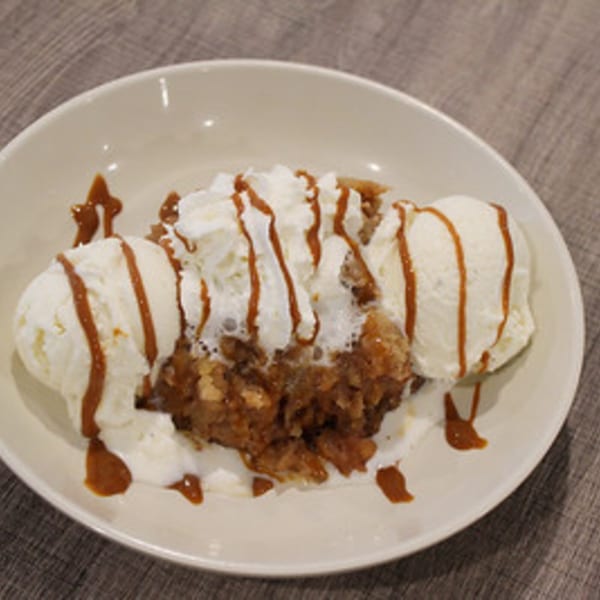 Marco Pizzeria's apple crumble dessert with vanilla ice cream, whipped cream, and caramel drizzle.