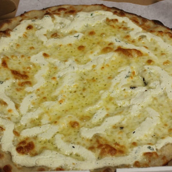 Close-up of a white pizza from Marco Pizzeria, topped with creamy ricotta and melted mozzarella.