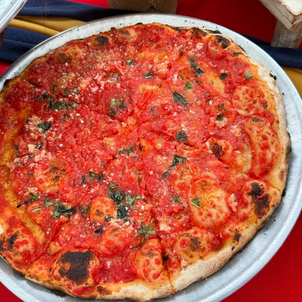 A whole Marco Pizzeria marinara pizza, topped with rich red sauce, basil, and grated cheese.