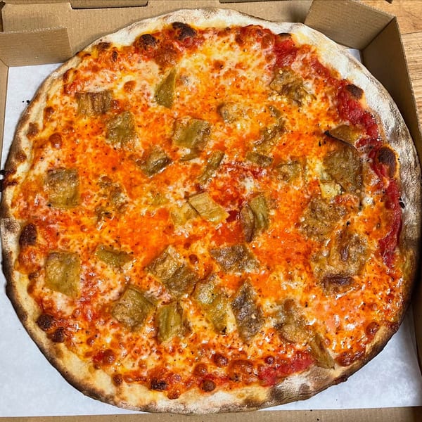 A whole Marco Pizzeria pizza with red sauce, melted cheese, and square toppings in a box.