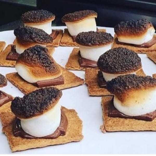 Several s'mores with perfectly toasted marshmallows and melted chocolate on graham crackers.